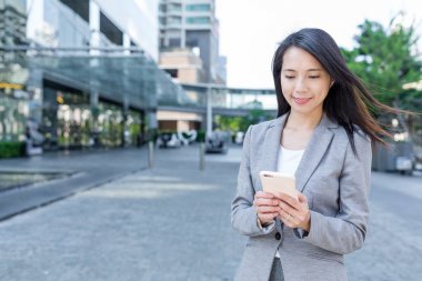 İş kadını akıllı telefon kullanıyor.