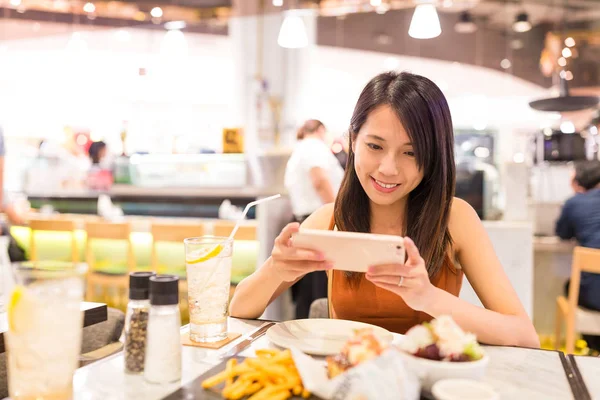 Femme prenant des photos au restaurant — Photo