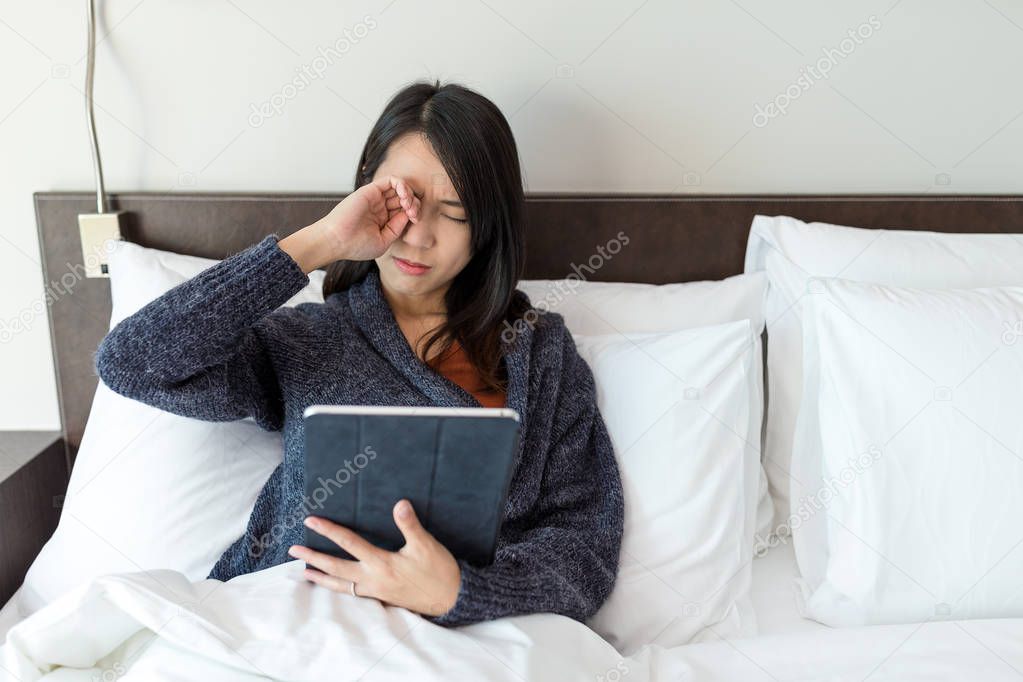 Woman feeling tired when using digital tablet 