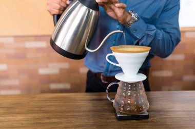 Kahveye filtreyle su döken barista. 