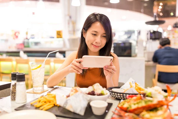 Frau fotografiert Geschirr in Restaurant — Stockfoto