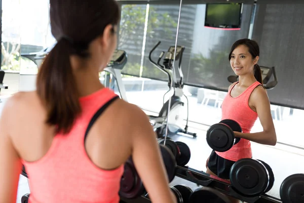 Femme soulevant haltère dans la salle de gym — Photo