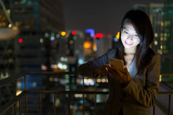 Empresaria trabajando en el teléfono móvil por la noche — Foto de Stock