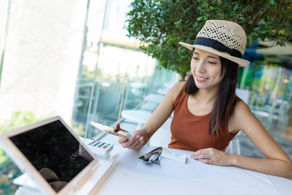 Woman pay with cellphone in cafe