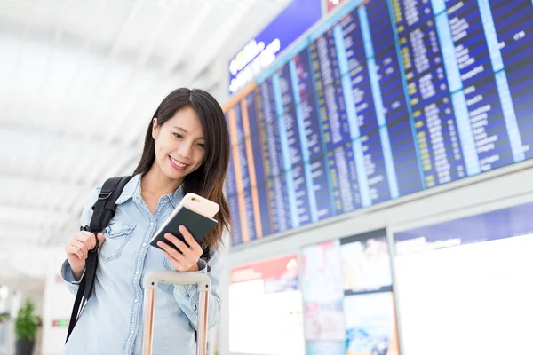Женщина с мобильного телефона в аэропорту — стоковое фото