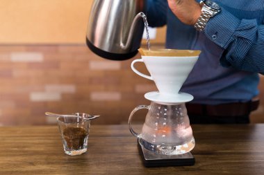 Kahveye filtreyle su döken barista.