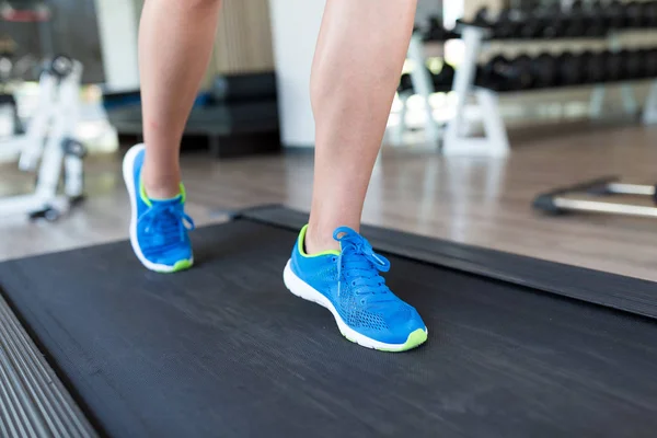 Kvinna kör på löpbandet i gym — Stockfoto