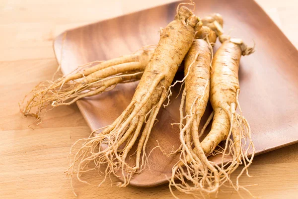 Raiz de ginseng fresco sobre fundo de madeira — Fotografia de Stock