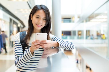 Alışveriş merkezinde cep telefonu kullanan kadın