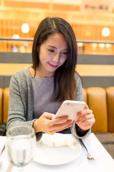 restoranda cep telefonu kullanan kadın