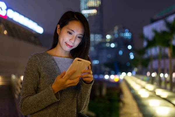 Mulher usando telefone celular à noite — Fotografia de Stock