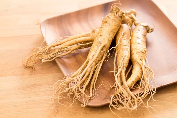 Ginseng root over wooden background — Stock Photo, Image