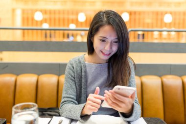 restoranda cep telefonu kullanan kadın