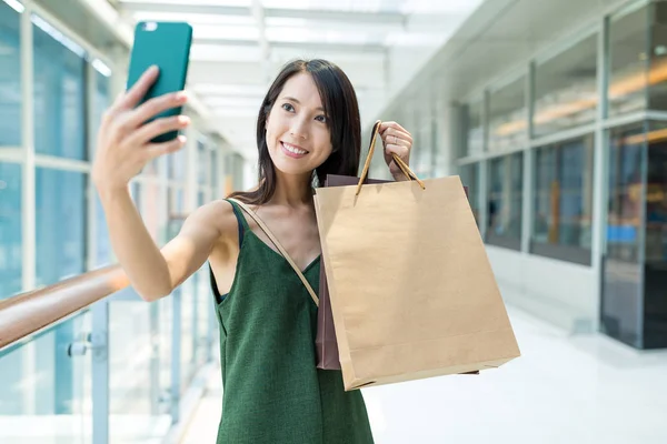 Mulher segurando sacos de compras e tirando selfie — Fotografia de Stock