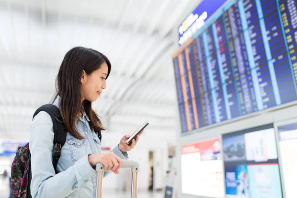 공항에서 휴대 전화에 비행기를 확인 하는 여자 — 스톡 사진