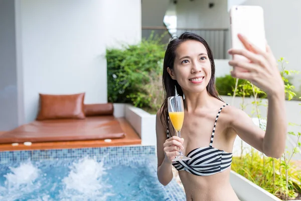 Жінка насолоджується соковитим напоєм і приймає селфі по мобільному телефону — стокове фото