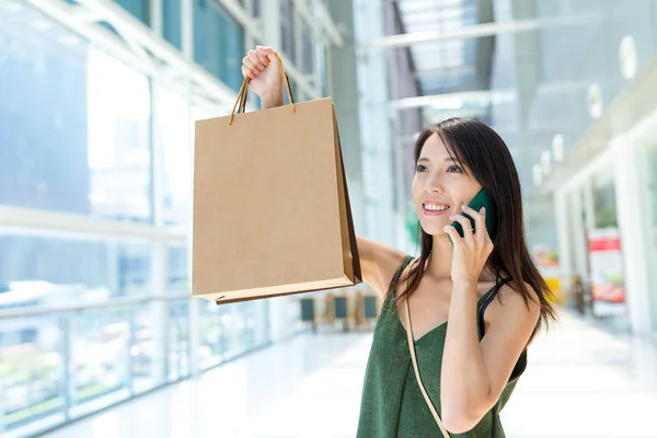 Nő a gazdaság bevásárló táskák, és beszél a mobiltelefon — Stock Fotó