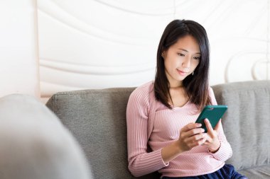 Evde cep telefonu kullanan bir kadın