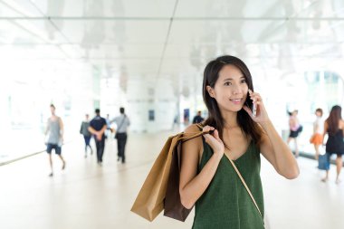 alışveriş torbaları holding ve cep telefonda konuşurken kadın