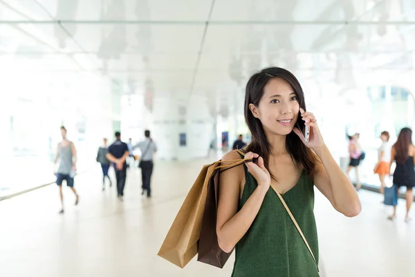 Femme tenant des sacs à provisions et parlant sur un téléphone mobile — Photo