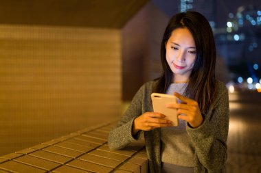 Gece akıllı telefon kullanan bir kadın.