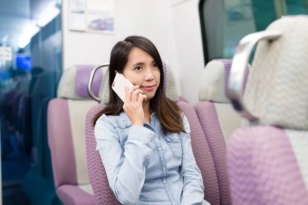Женщина разговаривает по мобильному телефону в поезде — стоковое фото