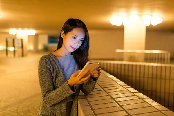 Kobieta za pomocą telefonów komórkowych w nocy — Zdjęcie stockowe