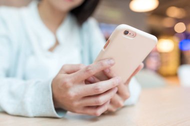 Kadın manifatura bir şey üzerinde cep telefonu