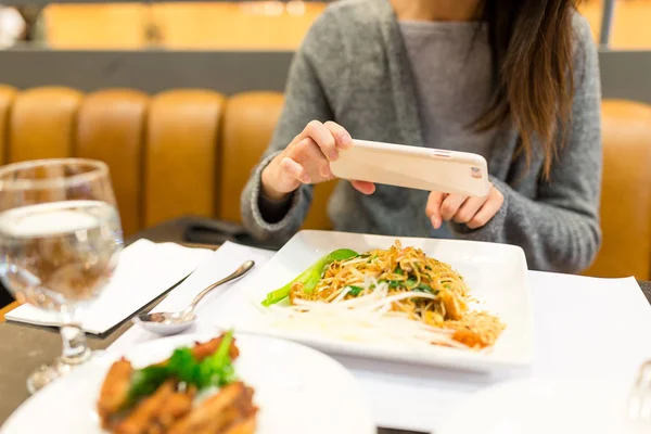 Vrouw nemen foto op gerechten in restaurant — Stockfoto