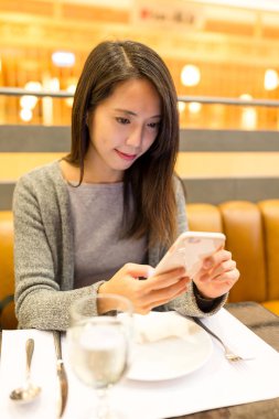 restoranda cep telefonu kullanan kadın