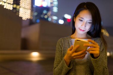 Hong Kong cep telefonu üzerinde çalışan kadın