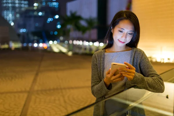 Mulher usando celular à noite — Fotografia de Stock