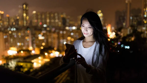 Mulher usando telefone celular à noite — Fotografia de Stock