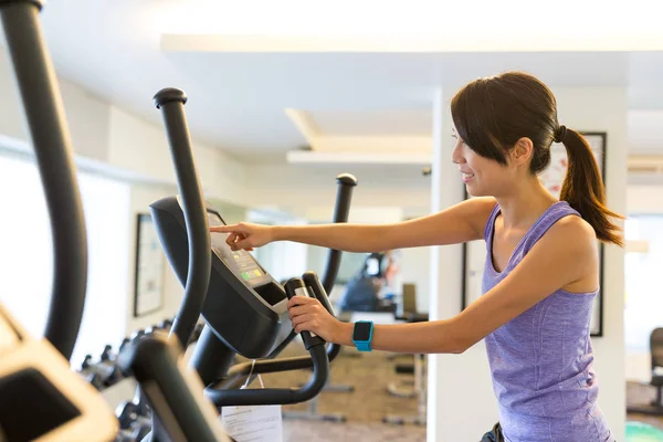 Femme de formation sur la machine elliptique dans la salle de gym — Photo