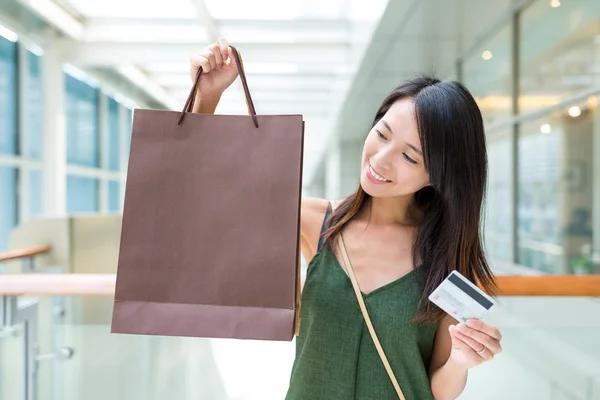 Nő gazdaság bevásárló táskák és hitelkártya — Stock Fotó