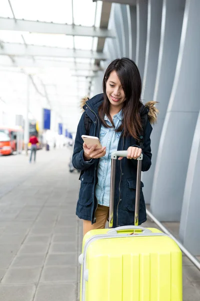 女人用手机与她的行李去旅行 — 图库照片