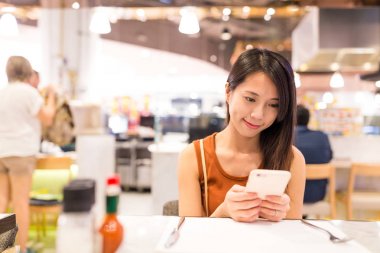 restoranda cep telefonu kullanan kadın