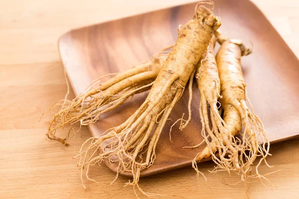 Ginseng fresco su piatto di legno — Foto Stock