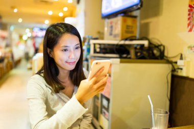 restoranda cep telefonu kullanan kadın