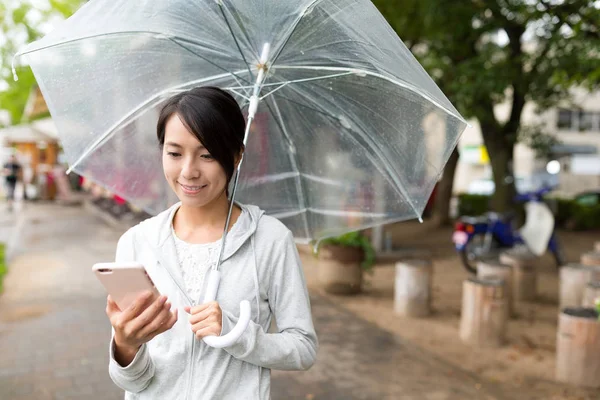 Frau benutzt Handy bei Regen — Stockfoto