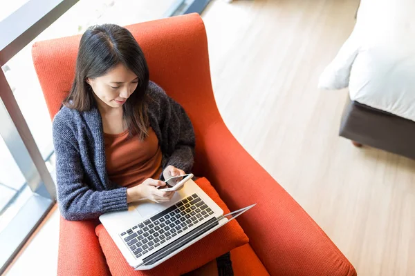 Vrouw met behulp van de mobiele telefoon en laptop computer — Stockfoto