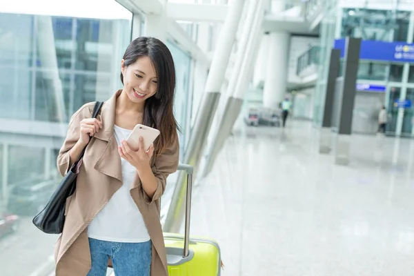 空港内の携帯電話で女性の搭乗番号を確認する — ストック写真