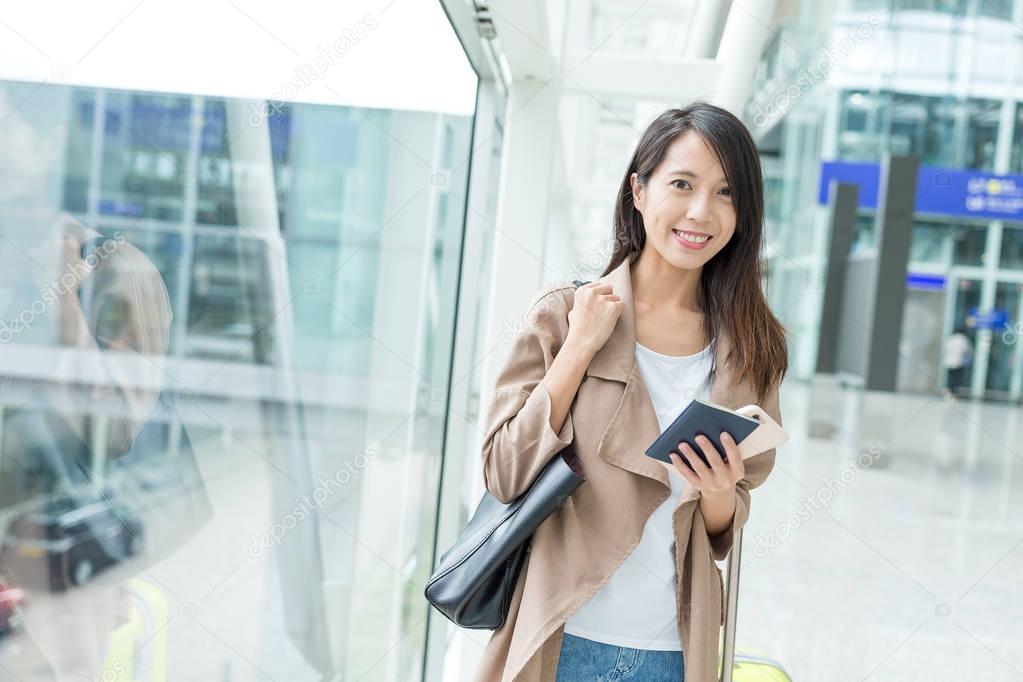 Woman check flight number on mobile phone in airport