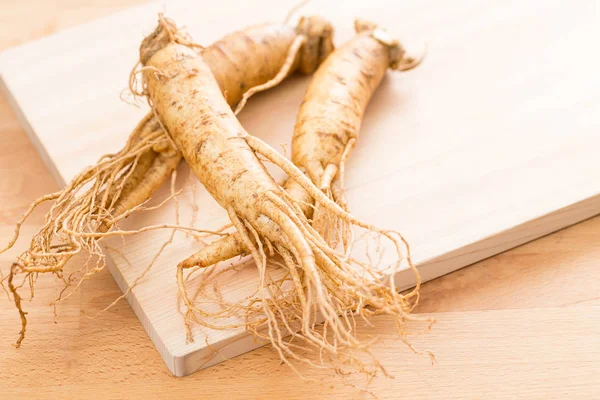 Ginseng fresco sobre textura de madeira — Fotografia de Stock