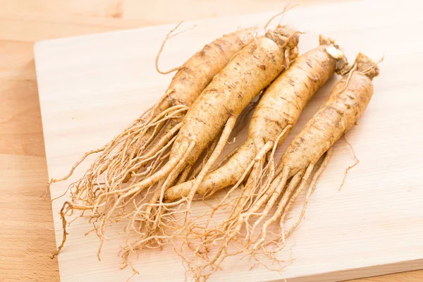 Fresh ginseng over wooden texture — Stock Photo, Image