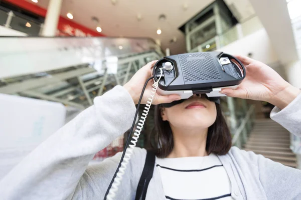 Женщина смотрит через VR устройство — стоковое фото