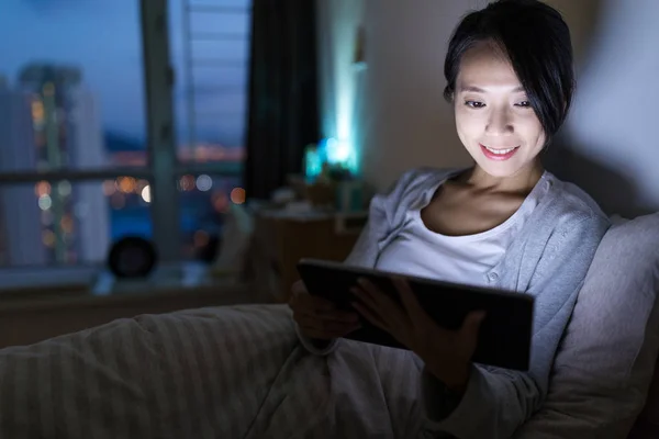 Женщина смотрит на цифровой планшет дома — стоковое фото