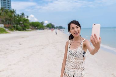 Kadın selfie cellphone tarafından sahilden alıyor.