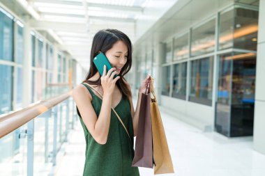 kadın alışveriş torbaları holding ve cep telefonunuzun konuşma