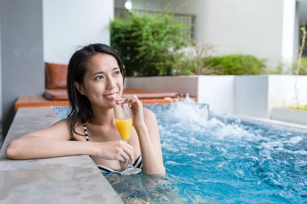Женщина в джакузи бассейн и насладиться напитком — стоковое фото